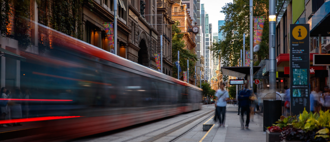 Busy city street with a tram in motion, showing urban activity and economic life.